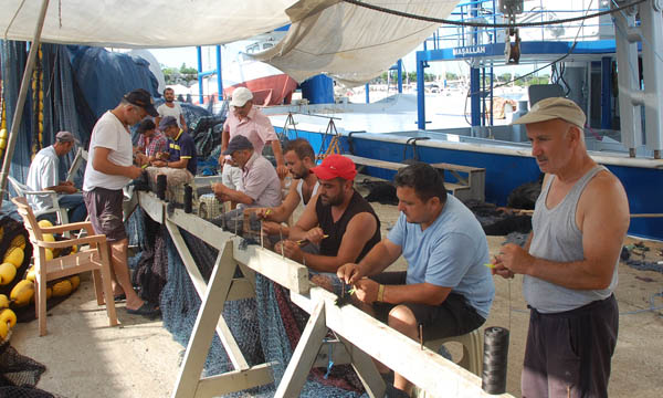 Balıkçılar ağlarını onarıyor